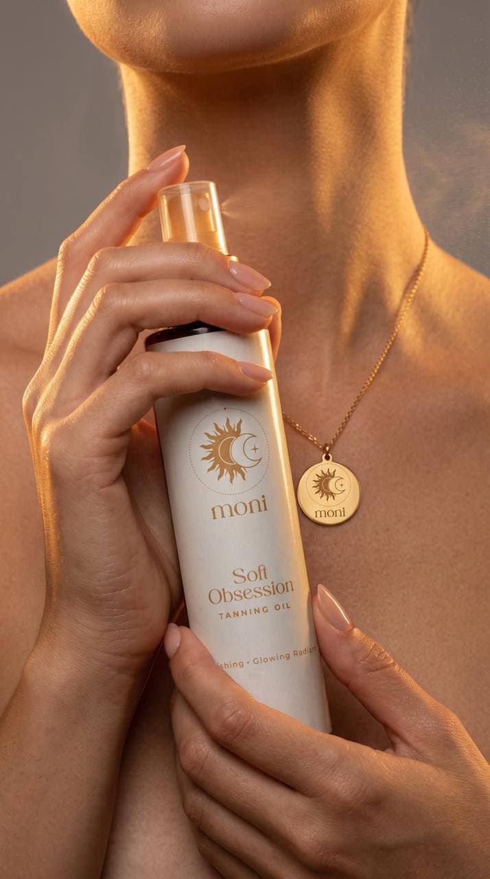 Woman holding MONÌ Soft Obsession Tanning Oil in warm golden light